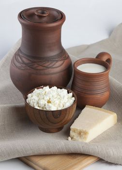 Jug, milk in mug, curds and cheese on the tablecloth