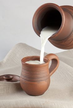 Steam of milk flowing in a mug on the tablecloth