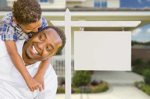 Happy African American Father and Mixed Race Son In Front of Blank Real Estate Sign and New House.