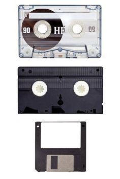 Old technology devices - Audio Cassette Tape, Video Tape and a Floppy Disc.