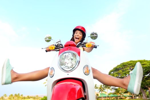 Funny happy free woman on scooter driving excited and cheerful. Mixed race Asian Chinese / Caucasian girl.