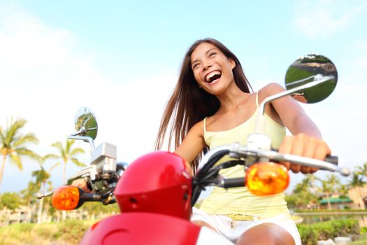 Happy free asian woman on scooter. Freedom concept with excited joyful asian woman driving scooter outdoor on summer vacation holidays.