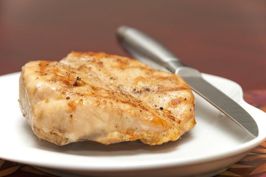 Grilled chicken breast with focus on the grill marks on top of the meat.
