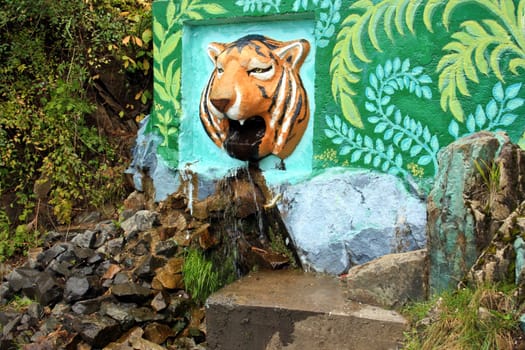 Water flows from a mouth of a stone tiger