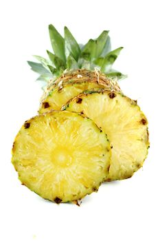 ripe pineapple with slices isolated on white background