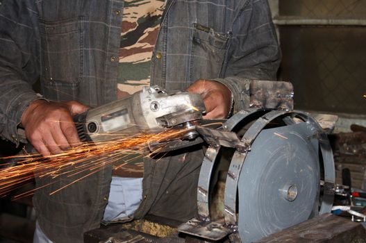 The expert cuts metal the electric tool