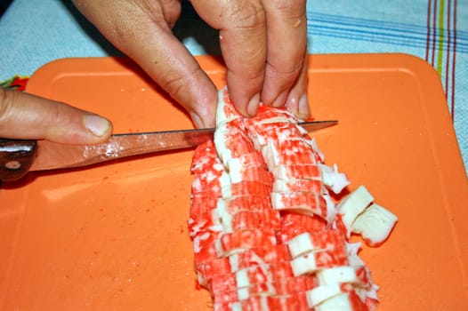 The person cuts meat of a crab