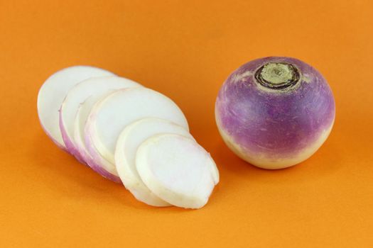 purple headed turnips with slices on orange background
