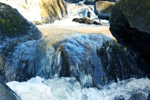 Water stream with foam among the big stones