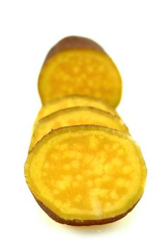 cutting sweet potatoes on white background