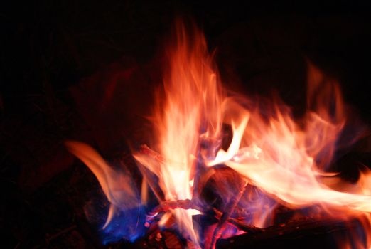 Red coals and fire in wild fireplace