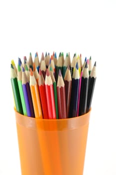 Color pencils in the orange prop over white. Shallow DOF.