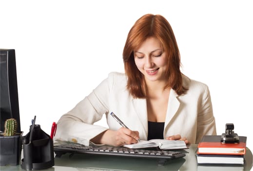 girl writes in a notebook sitting at a desk in an office on a white background isolated