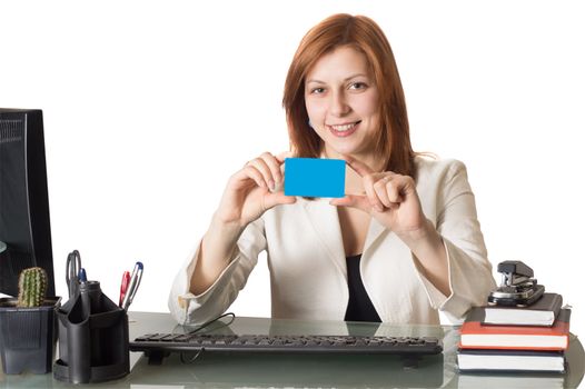 Woman banker holds a credit card in hand sitting at a desk in an office on a white background isolated