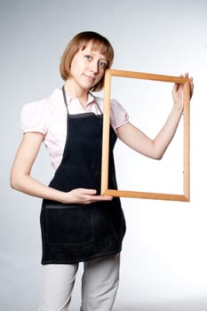 young girl in an apron holding a frame