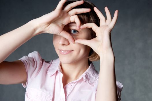 young girl shows gesture in the form of heart