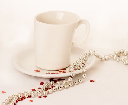 Coffee cup on a white background with red glitter hearts