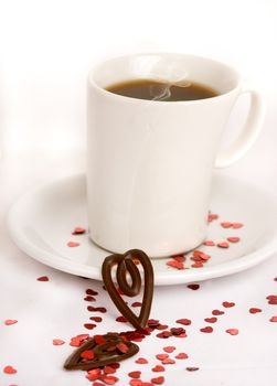 Coffee cup on a white background with red glitter hearts