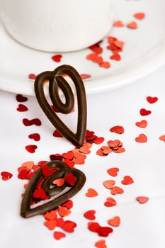 Coffee cup on a white background with red glitter hearts