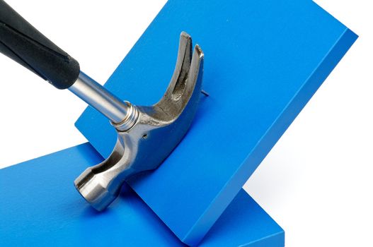 Hammer Pulling Nail Out of Square Blue Plank closeup on white background