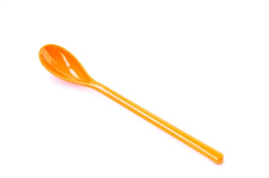 An orange plastic spoon on a white background