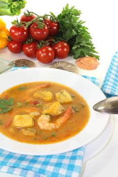 fresh bouillabaisse with seafood and parsley on a light background
