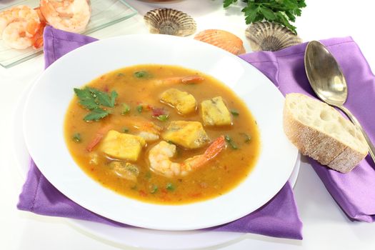 healthy bouillabaisse with seafood and parsley on a bright background