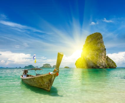 Long tail boat on tropical beach (Pranang beach) and rock, Krabi, Thailand