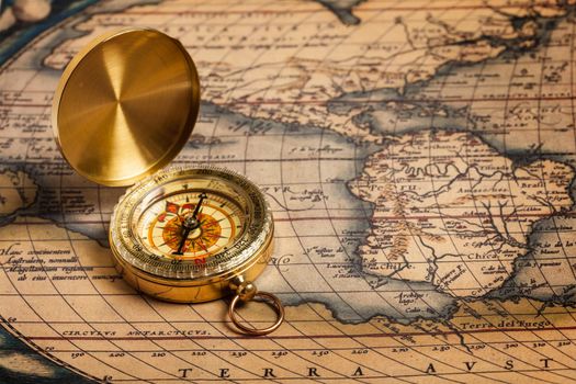 Old vintage retro golden compass on ancient map