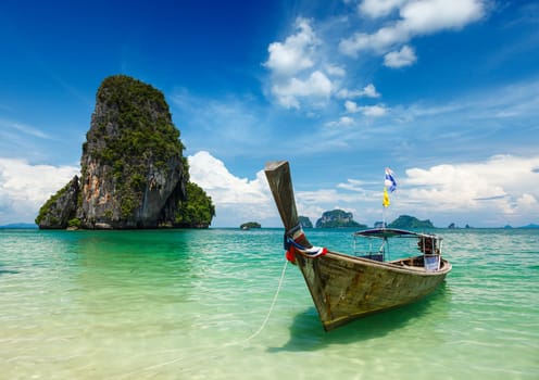 Long tail boat on tropical beach (Pranang beach) and rock, Krabi, Thailand