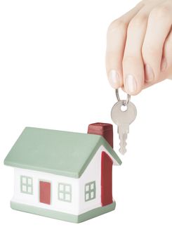 Little house toy and hand with key isolated over white background