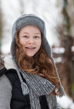 Outdoor portrait of a cheerful teenager girl in winter cloths