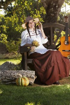 View of a beautiful girl in a classic dress in a countryside set.