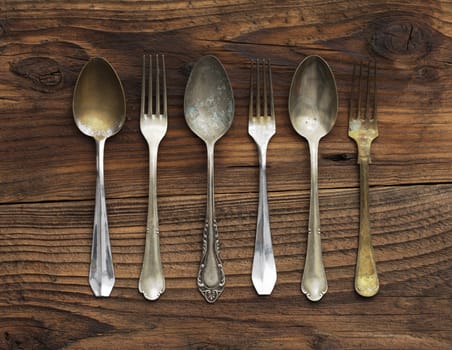 Old forks and spoons on wooden background
