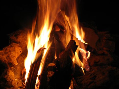 Closeup of burning red fire wood on black background