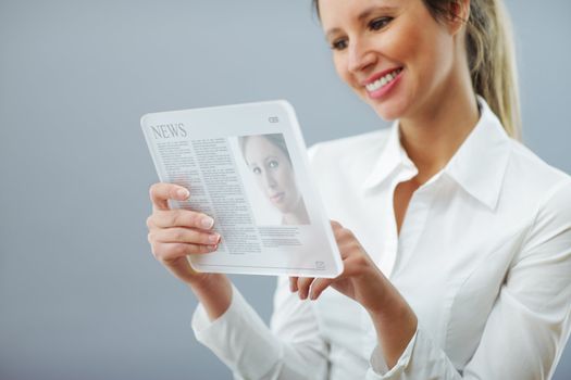 Young business woman reading news on digital tablet