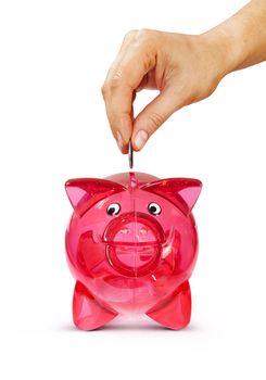 Woman's hand putting coin into piggy bank, isolated on white with path