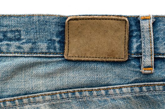 Highly detailed closeup of blank grungy stained leather label on old blue jeans with lot of seams, some kind of background