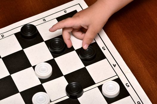 little boy plays checkers