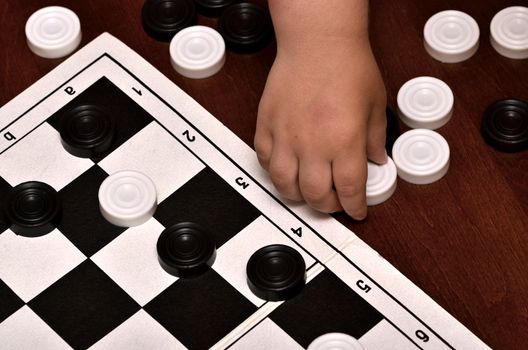 little boy plays checkers