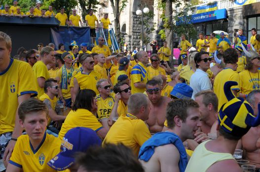 KIEV, UKRAINE - JUNE 19: Swedish football fans relax in the official fan zone of EURO-2012 in the center of Kiev, June 2012. EURO 2012 is a European football championship held by UEFA.