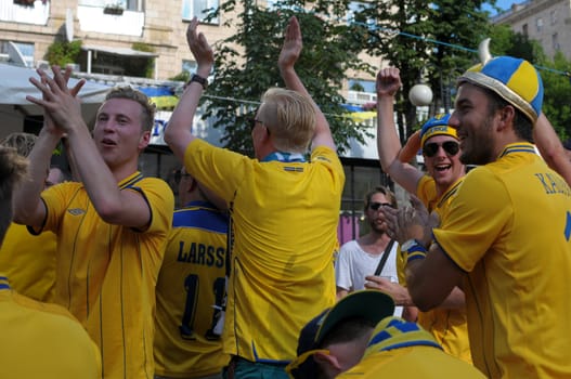 KIEV, UKRAINE - JUNE 19: Swedish football fans relax in the official fan zone of EURO-2012 in the center of Kiev, June 2012. EURO 2012 is a European football championship held by UEFA.