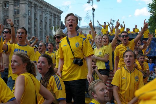 KIEV, UKRAINE - JUNE 19: Swedish football fans relax in the official fan zone of EURO-2012 in the center of Kiev, June 2012. EURO 2012 is a European football championship held by UEFA.