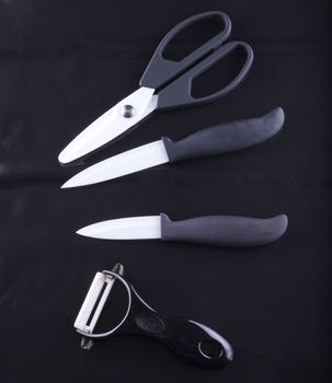 Different kinds of white ceramic cutlery over black