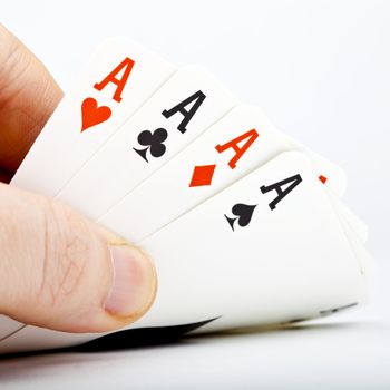 Hand and Four Aces over a white background.