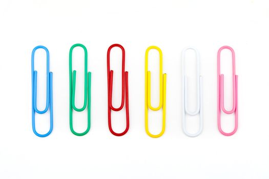 Different Colored Paper Clips over a white background.