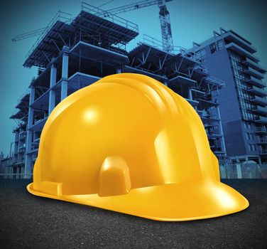 Construction industry and commercial real estate business investment with a yellow builder hard hat and a high rise structure being built as a symbol of economic and financial growth and healthy economy.