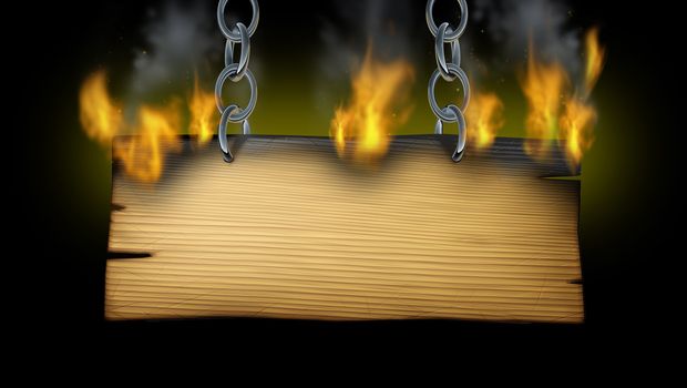 Burning wooden sign with fire flames and smoke on an old wood plank with metal chains holding the signage as a western or rustic hot message advertisement on a black background.