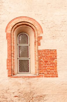 the antique window in stone wall with red bricks