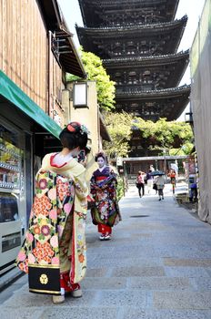 KYOTO, JAPAN - OCT 21 2012: Japanese ladies in traditional dress  on a street leading to Kiyomizu Temple on October 21 2012. Kiyomizu is a famous temple in Kyoto built in year 778.